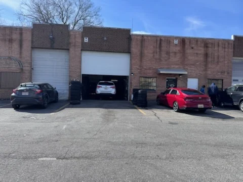 Cars parked across the forecourt in front of the shop on a clear day.