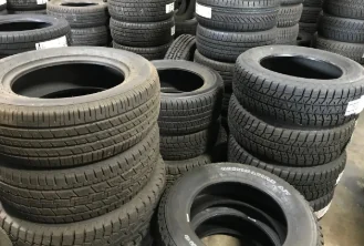 Stacks of part-worn tires with their treads and sidewalls visible.